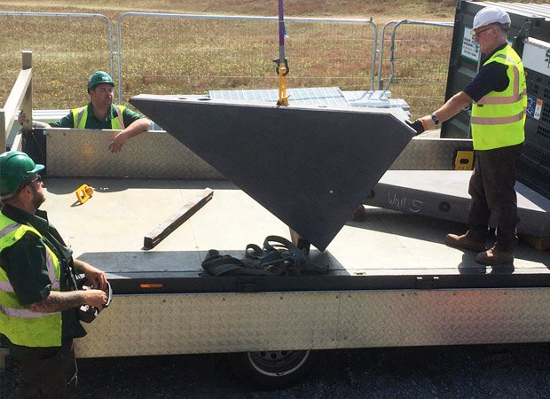Visual Concrete section piece being crane lifted off of truck